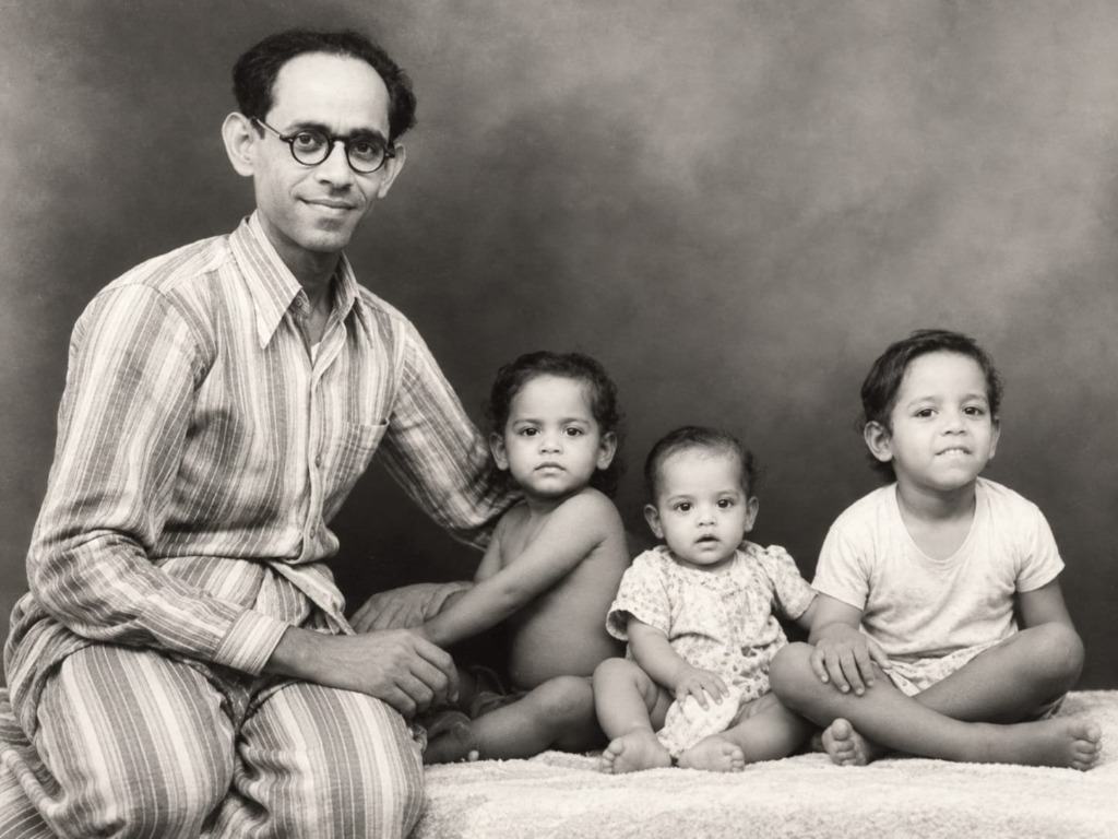 An esteemed physician in round glasses seated with three young children in Rajasthan